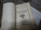 un vieux livre posé sur une table, à côté d'autres livres