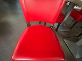 une chaise rouge qui se trouve au milieu d'une pièce