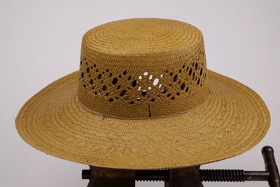 chapeau de paille marron avec des trous sur le bord du chapeau