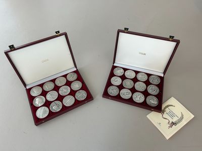 two silver coins are in a wooden case on a table