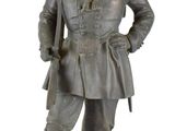 statue d'un homme coiffé d'un chapeau et vêtu d'un uniforme, debout, les mains sur les hanches
