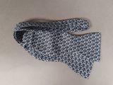 a close up of a tie on a table next to a pair of gloves