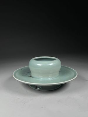 a green cup and saucer sitting on a saucer