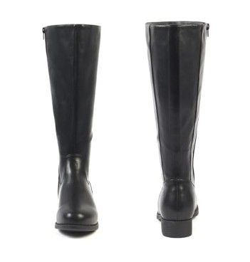 gros plan d'une paire de bottes noires sur fond blanc