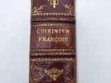 an old book with gold writing on it sitting on top of a table