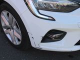 a close up of a white car that is parked in a parking lot
