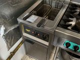 une photo d'une cuisine professionnelle équipée de deux friteuses et d'un évier