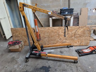 une grue qui se trouve dans un garage avec des outils