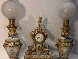 three vases and a clock sitting on a table