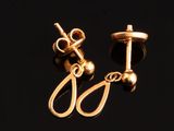 deux paires de boucles d'oreilles plaquées or sur un fond noir