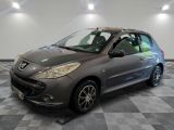La petite voiture grise est garée dans le garage, sur un sol à damier.