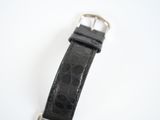 black leather watch strap with silver buckle on a white surface