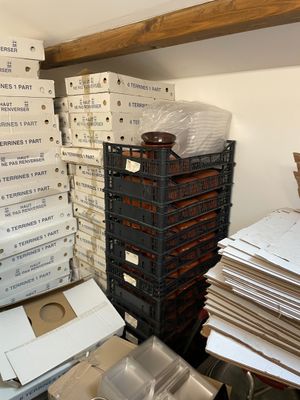 une pile de cartons, les uns sur les autres, posée sur une étagère dans une pièce remplie de cartons