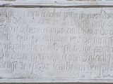 une plaque apposée sur le mur d'un immeuble, sur laquelle figurent des inscriptions