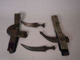 three old knives are laying on a white surface