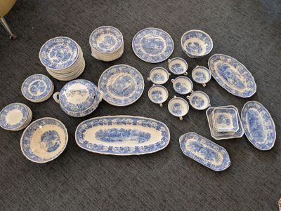 a lot of blue and white plates and bowls on the floor