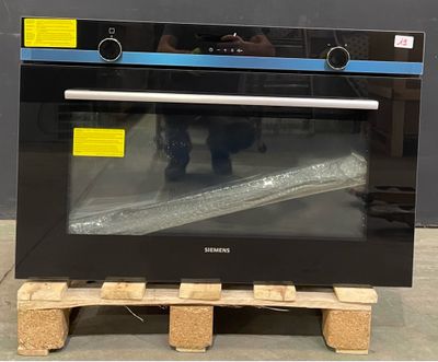 a black oven sitting on a pallet in a warehouse