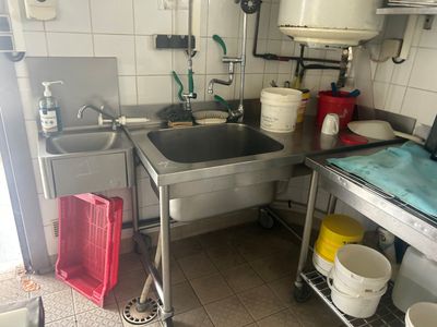 une petite cuisine équipée d'un évier, d'une cuisinière et d'autres appareils électroménagers