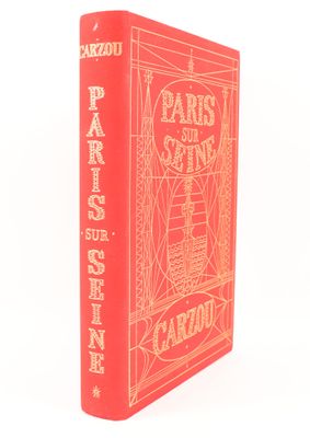 a red book sitting on top of a table next to a white wall