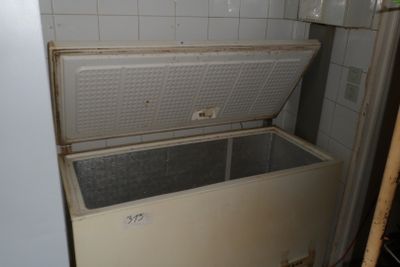 a white chest freezer sitting in the corner of a room