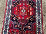 un tapis rouge et bleu posé sur un sol en béton