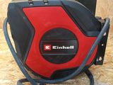 a red and black air compressor sitting on top of a wooden floor