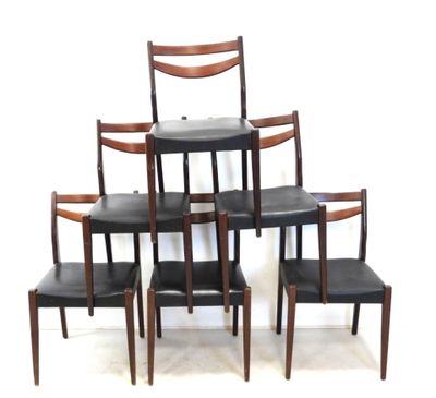 four chairs and a table in a room with a white wall