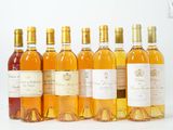 six bouteilles de vin sont alignées sur une surface blanche