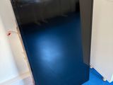 a black refrigerator in the corner of a room