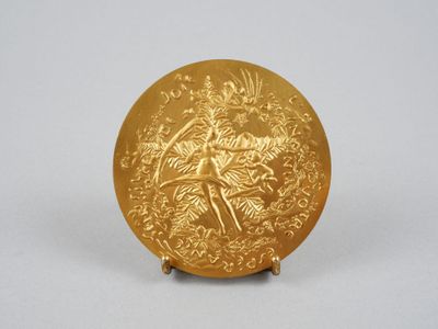 une image représentant une assiette en or ornée d'un oiseau et de fleurs