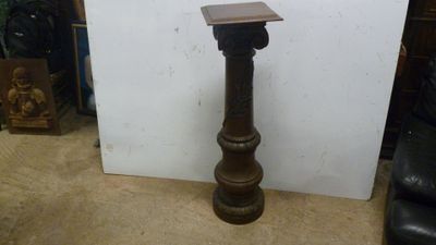 une petite table en bois posée à même le sol, à côté d'une chaise noire