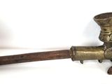 an old brass pipe with a hat on top of it