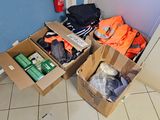 des cartons contenant des vêtements et d'autres objets posés par terre