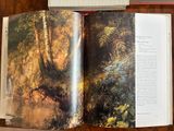 an open book on a table with a picture of a forest