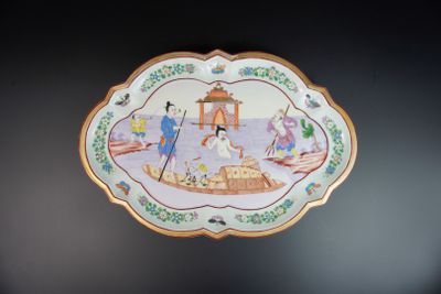 une assiette décorée d'une peinture, accrochée au mur