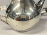 a silver tea pot sitting on a white table