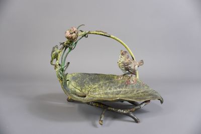 un oiseau perché sur une feuille où se trouve une fleur