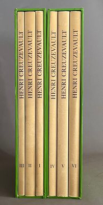 trois livres dans une boîte verte posée sur une table