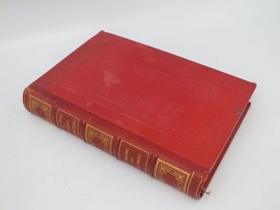 un livre rouge posé sur une surface blanche