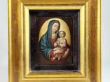 a painting of a woman holding a child in a gold frame