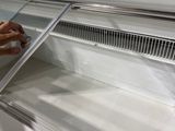 a person reaching into a refrigerated freezer
