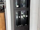 une armoire noire à portes vitrées, placée dans un coin de la pièce