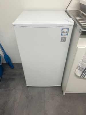 a small white refrigerator next to a sink in a kitchen