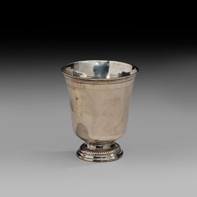 an image of a silver cup on a pedestal on a gray background