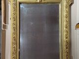 a gold framed mirror on the wall in a room