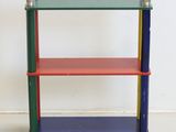 brightly colored bookshelf on wheels against a white wall