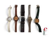 several watches are lined up in a row on a white surface