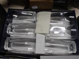 six empty wine glasses in a box on a table