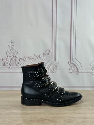 des bottines noires cloutées posées sur une surface en bois