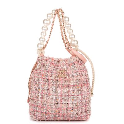 un sac en tweed rose et blanc avec des perles sur la poignée